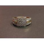 A 9ct gold diamond ring, sixteen diamonds in square setting with two row diamond set shoulders,