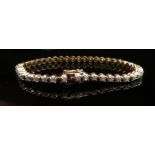 A diamond tennis bracelet stamped 14KP, 18cm long, 14.