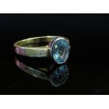 An 18ct gold oval aquamarine ring with rub over set diamond chips to shoulders, size P,