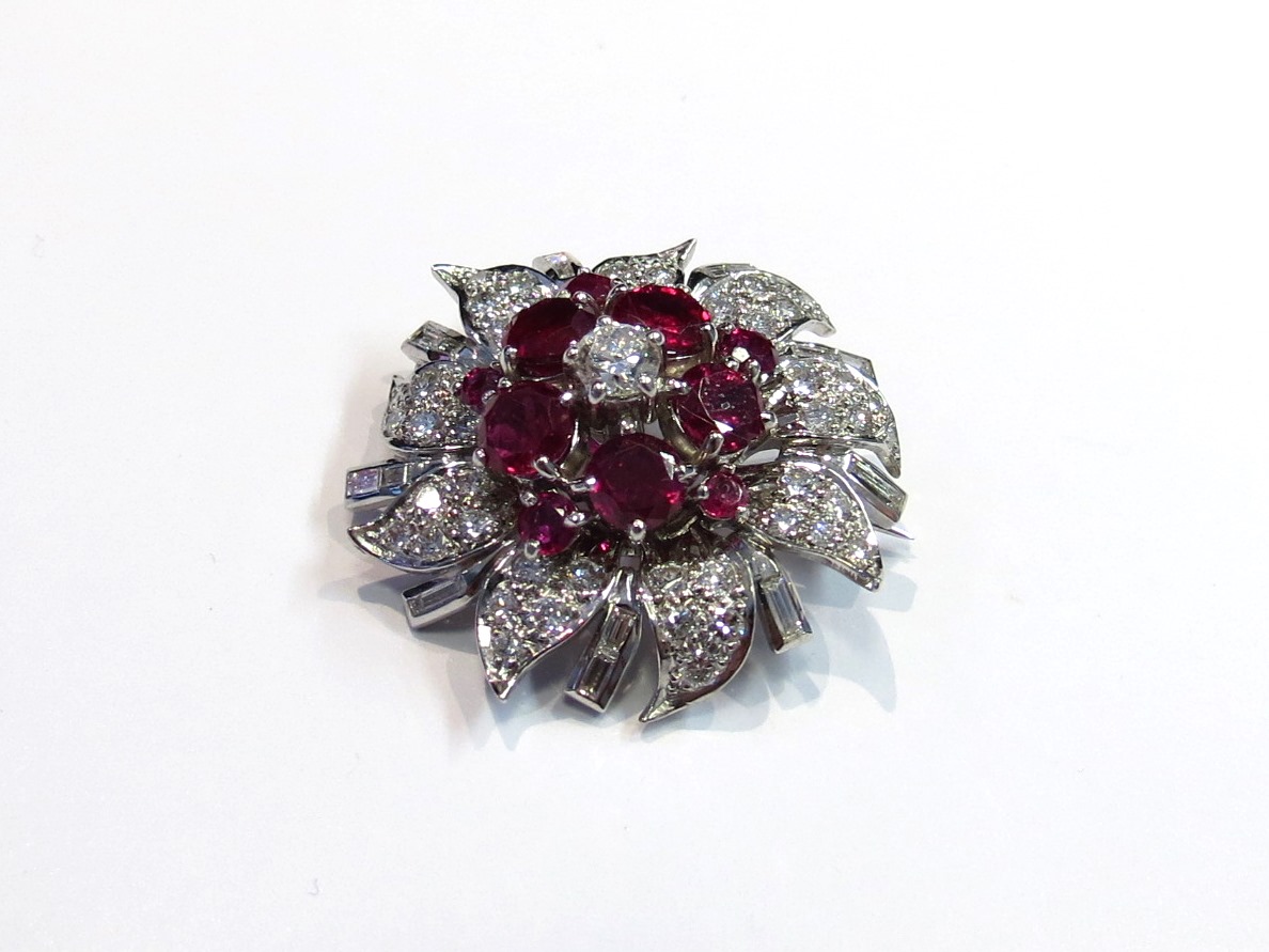 A diamond and ruby floral encrusted brooch the centre diamond .25ct approx.