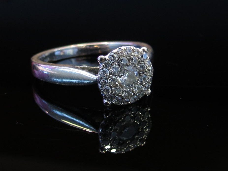 A white gold diamond cluster ring stamped 750, size Q,