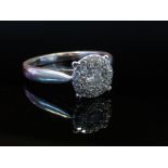 A white gold diamond cluster ring stamped 750, size Q,