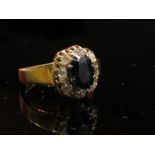 An 18ct gold sapphire and diamond cluster ring, size M/N, 7.