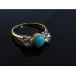 A gold ring with central cabochon turquoise flanked by diamonds, unmarked, size S,