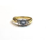 An 18ct gold ring, the central heart-shaped pale blue sapphire flanked by diamonds, size L, 3.