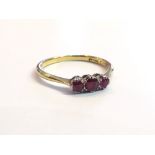 An 18ct gold three stone ruby ring, size P, 2.