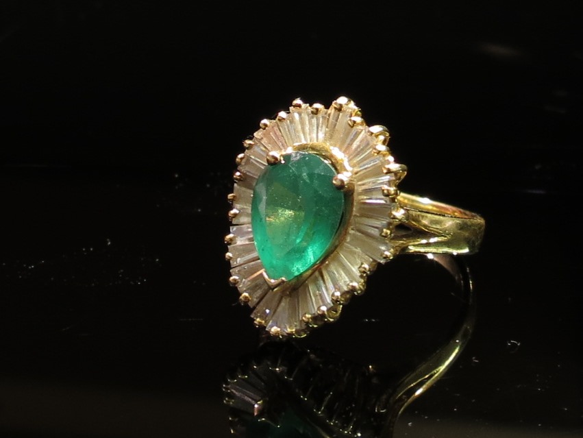 A gold diamond and emerald ring,