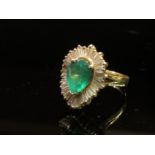 A gold diamond and emerald ring,