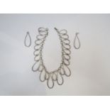 A silver necklace of linked loops,