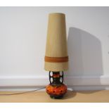 A West German pottery floor lamp with orange lava glaze over brown original shade.
