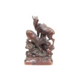 A late 19th/Early 20th Century Black Forest carved figural group of deer on a naturalistic base