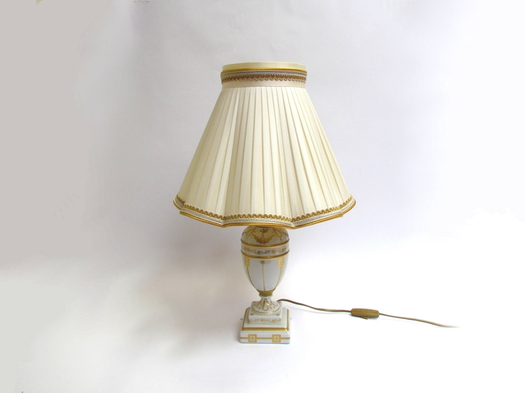 An Italian porcelain table lamp with gilt design and pleated silk shade