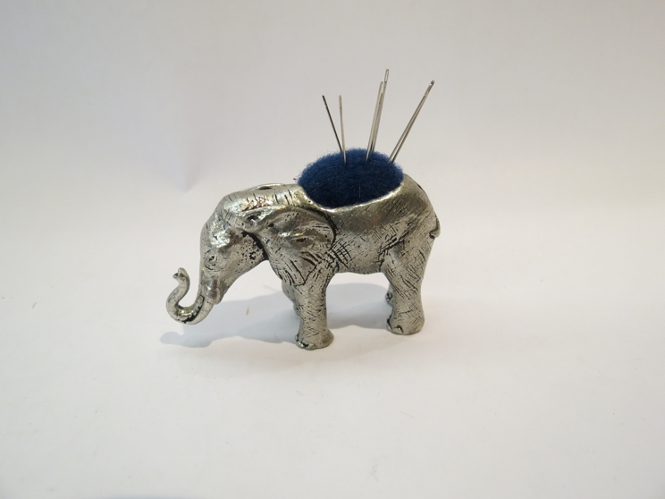 A plated elephant pin cushion