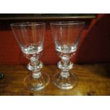 A pair of heavy crystal wine goblets with bulbous stems