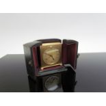 A Deco miniature brass alarm clock with Arabic numerals, Swiss made in travel case, 5.