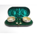 A pair of Thomas Hayes Victorian silver embossed salts with matching spoons, cased, Birmingham 1898,