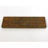 A trench art cribbage board crafted from brass and white webbing