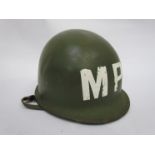 A WWII era US army helmet with liner, later MP decal.