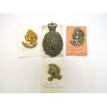 An Artists Rifles 21st SAS silver plated brass cap badge together with three others.