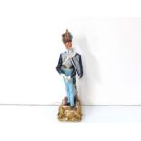 A Naples figurine of a Napoleonic soldier in blue dress