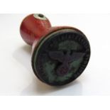A rubber stamp with central eagle over a swastika,