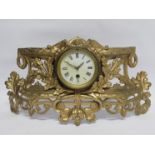 A late 19th Century French single train drum timepiece housed in a curved gilt cast metal frame