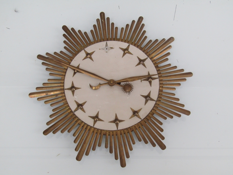 A Mid 20th Century mechanical sunburst wall clock with brass rays,