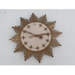 A Mid 20th Century mechanical sunburst wall clock with brass rays,