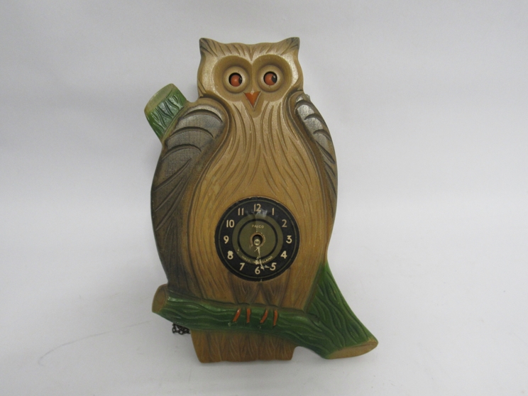 A 20th Century Paico novelty wooden owl wall clock with moving eyes, pendulum and weight,