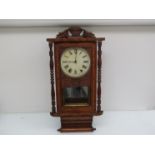 An early 20th Century American walnut and inlaid eight day spring driven wall clock with glazed