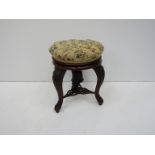 A Victorian walnut revolving piano stool,