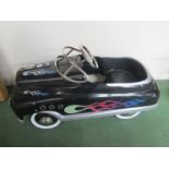 A black pedal car with blue flame design