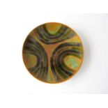 A Poole Studio plate, c1964-66 in green, black and ochre colours. Blue back stamp. 20.