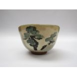 A Japanese studio pottery chawan, oatmeal glaze and painted with trees. Indistinct impressed seal.