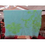 A turquoise and green floral patterned throw