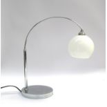 A chrome arch table lamp with opaque glass shade