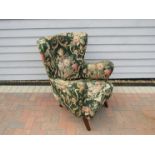 A 1940's Danish wingback armchair, original green floral upholstery,