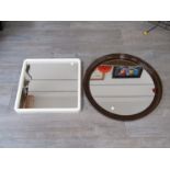 A circular mirror with curved smoked perspex surround and a square mirror with a white plastic