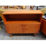 A Danish teak cabinet, twin doors revealing shelved interior, open bookcase above,