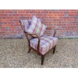 A 1940's low armchair, the frame stained in dark oak,