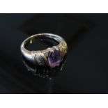 A 9ct gold ring set with central oval amethyst, diamond chips to shoulders, size L,