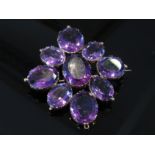 A large amethyst brooch the central oval amethyst framed by eight various sized ovals, unmarked, 25.