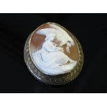 A carved shell cameo brooch depicting Hebe feeding the Eagles in unmarked gold frame
