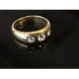 An 18ct gold ring set with three diamonds in rub over setting size O, 5.7g, .