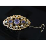 A 9ct gold ornate brooch set with pearls and amethysts. 10.