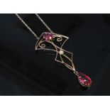 An Art Nouveau style pendant necklace hung with red glass droplet, stamped 9ct. 3.