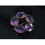 An amethyst brooch with five oval amethysts in a circle,