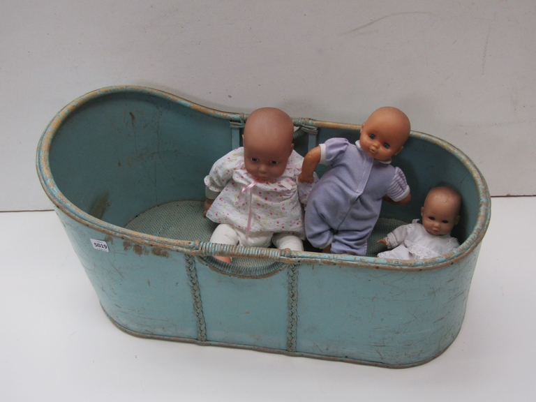 An early 20th Century blue painted cot and three vinyl dolls