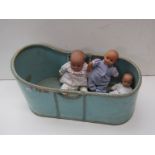 An early 20th Century blue painted cot and three vinyl dolls