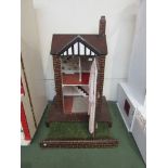 An Edwardian handmade doll house with slide out lawn,